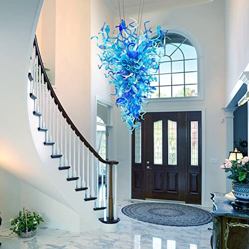 An elegant foyer with a spiral staircase and a blue glass chandelier.